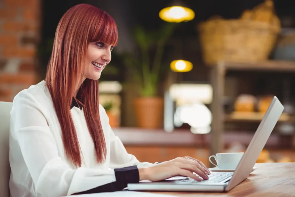 female event planner working on a computer and smiling