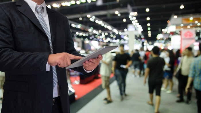 Man managing attendees with tablet and selling event tickets online.