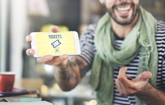 Man met mobiel ticket die de beste manieren uitlegt om tickets online te verkopen