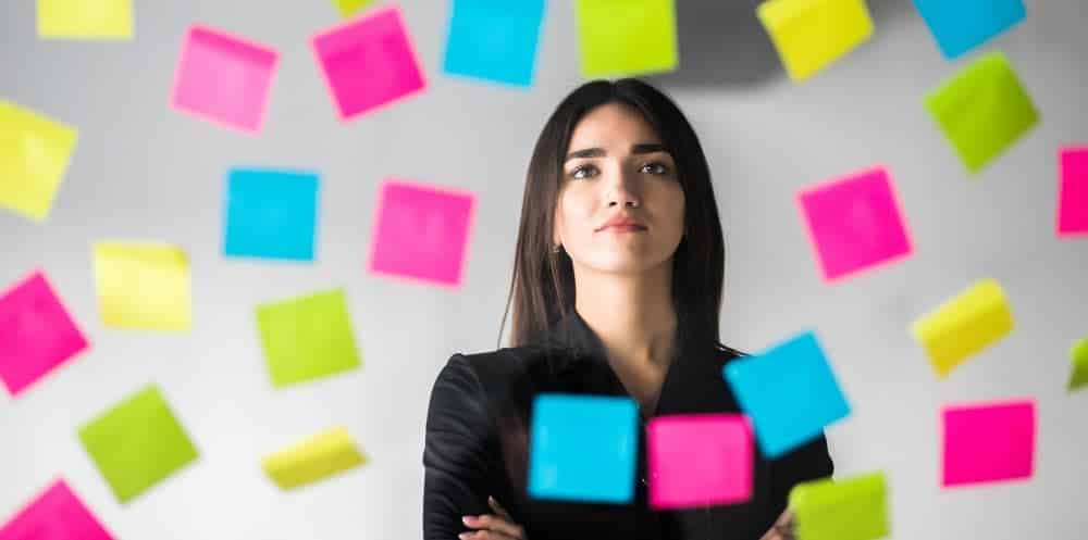 event planner looking at colourful post its and thinking about the event planning process steps