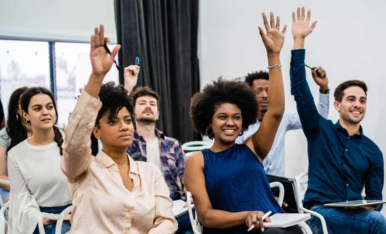 sales partners raising their hands at a workshop promoted with Timely corporate learning management system software