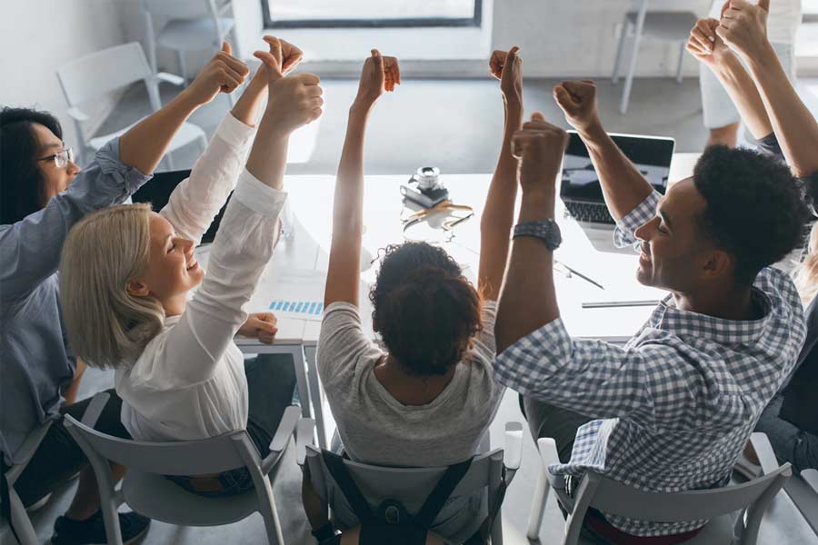 teammedlemmer med tommelfingeren op og godkender den nye leverandør af event management software