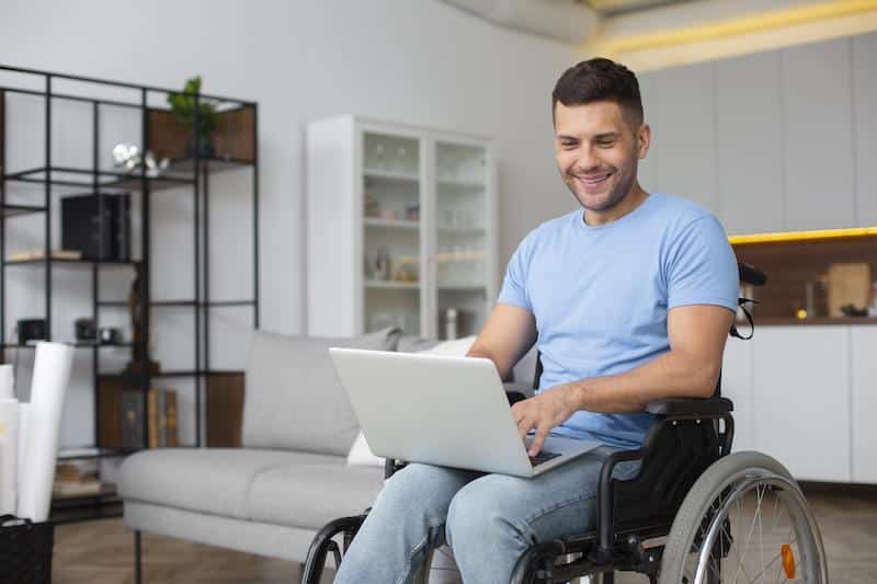 man on wheelchair interacting with a website built considering digital accessibility