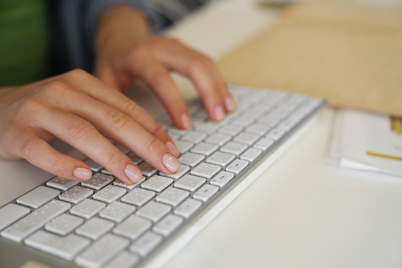 blind woman typing on a braille keyboard searching for events on Timely's accessible event platform