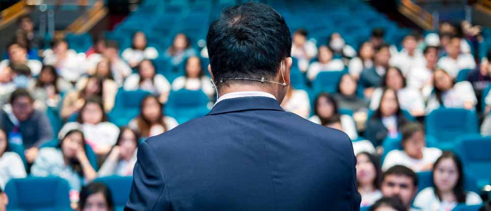 man die een lezing geeft voor een druk publiek tijdens een evenement van het type conferentie