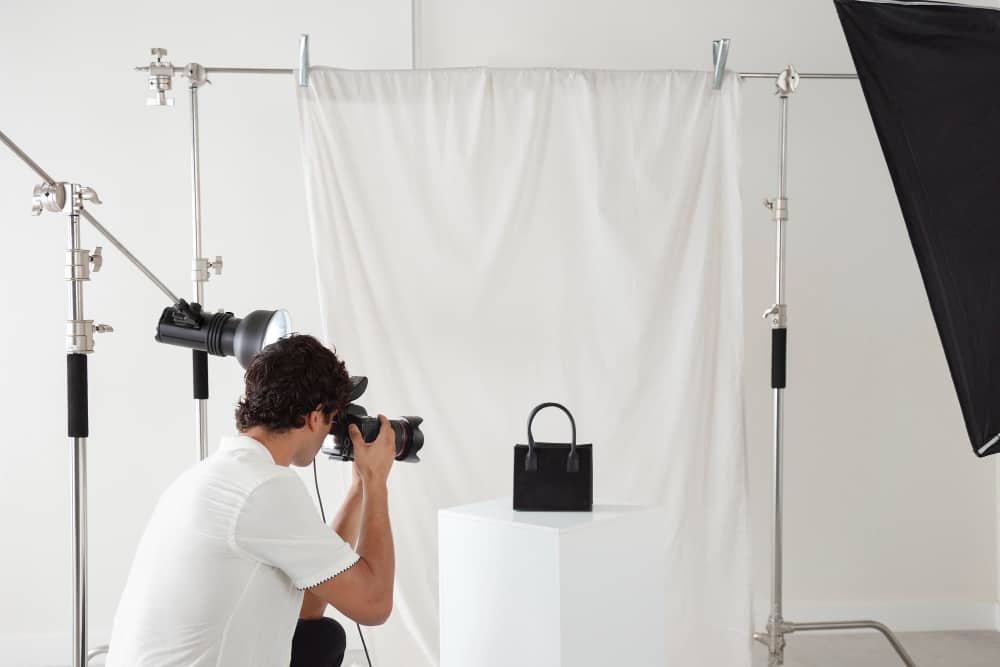 man on a photography studio showing how to photograph a product during a company workshop