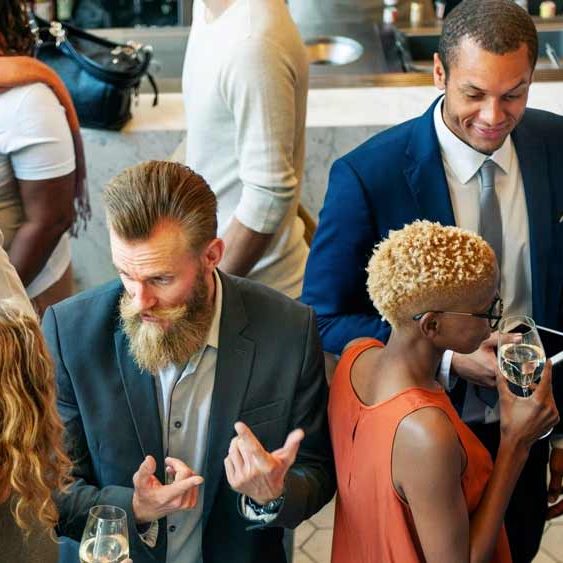 A diverse group of young professionals at a business networking event building relationships and exchanging ideas