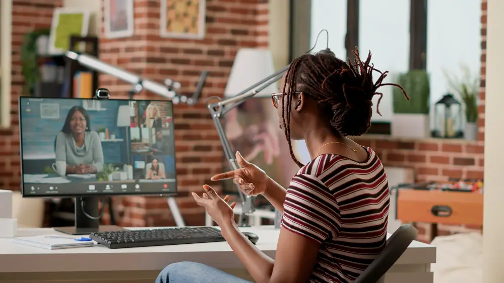 a woman leading a professional online training to another woman through a computer screen.