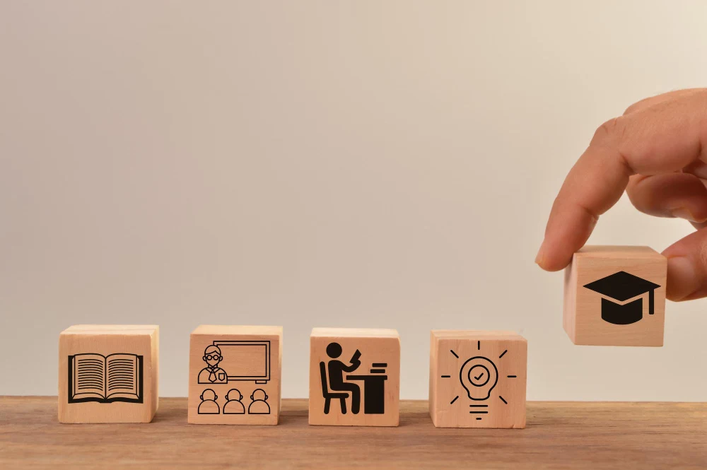 Five small wooden blocks with images that depicts learning and development and the 70 20 10 rule.