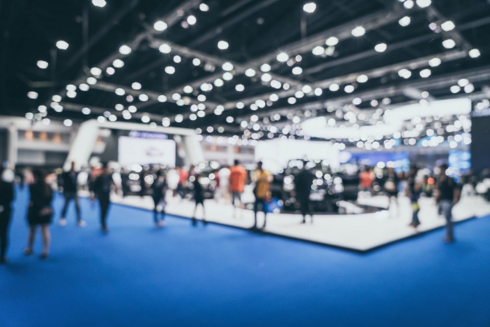 a trade show with blue floors and bright lights.