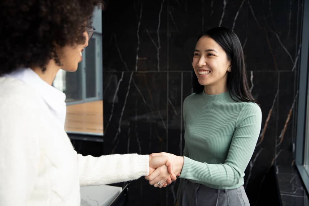 two women shaking hands.