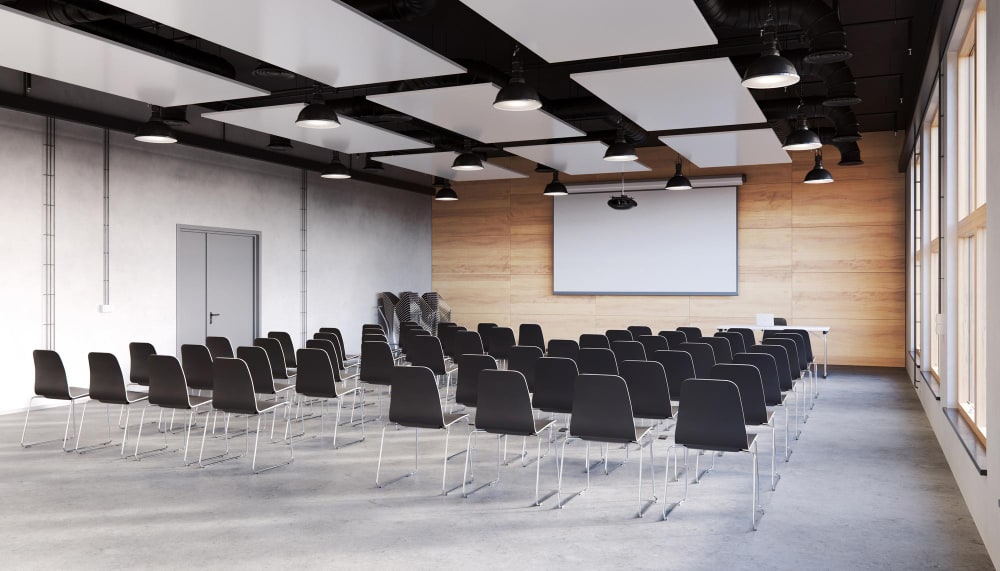 a simple option for renting a venue: a clear room with chairs, good lighting and a white screen.