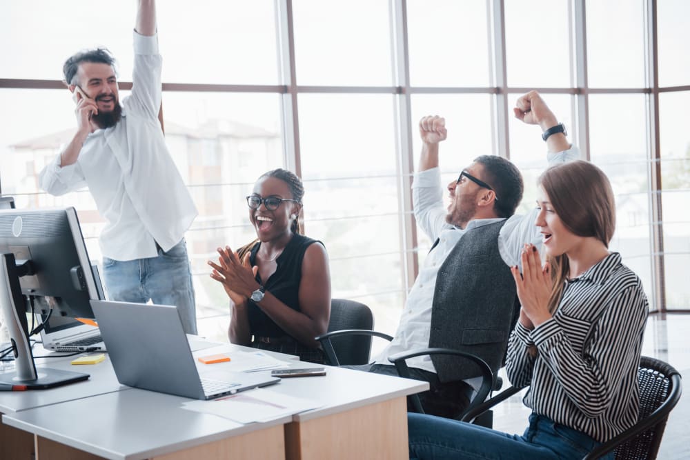 group of event management professionals at an office cheering.