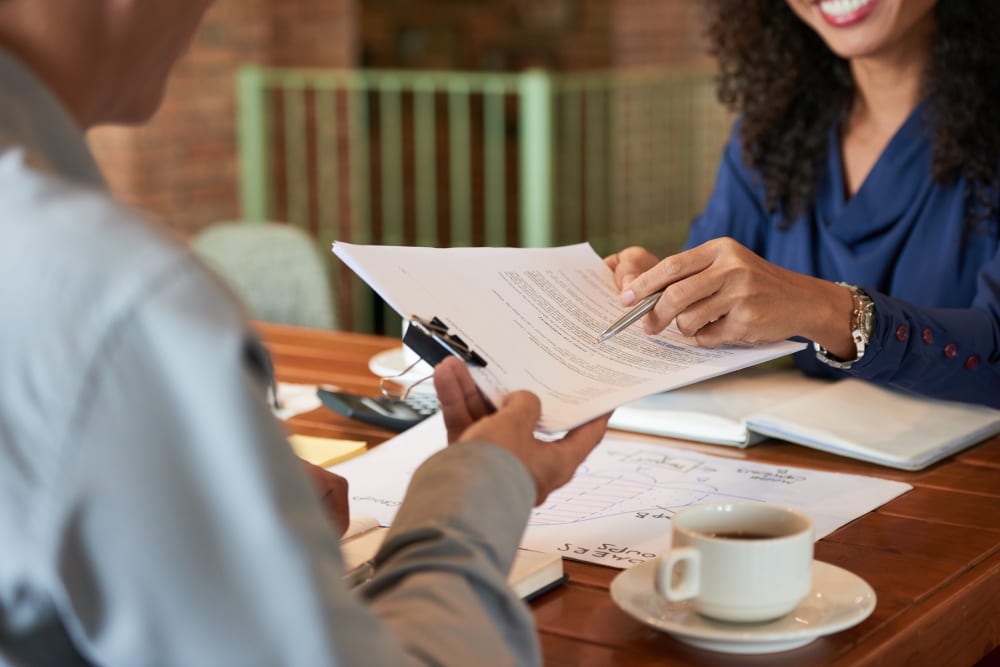 Female lawyer reviewing event planner contract template with event professional.