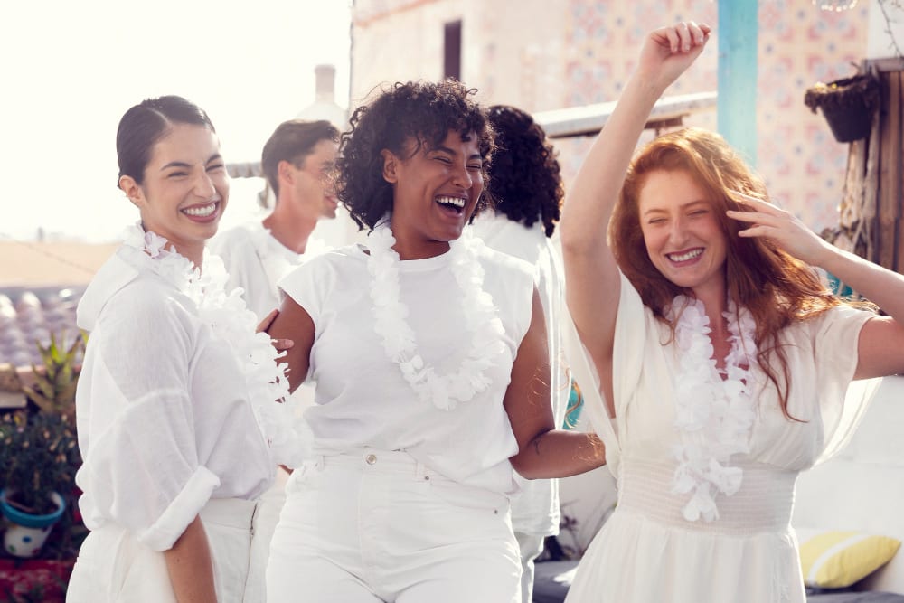 young women dressed in white, celebrating at a party.