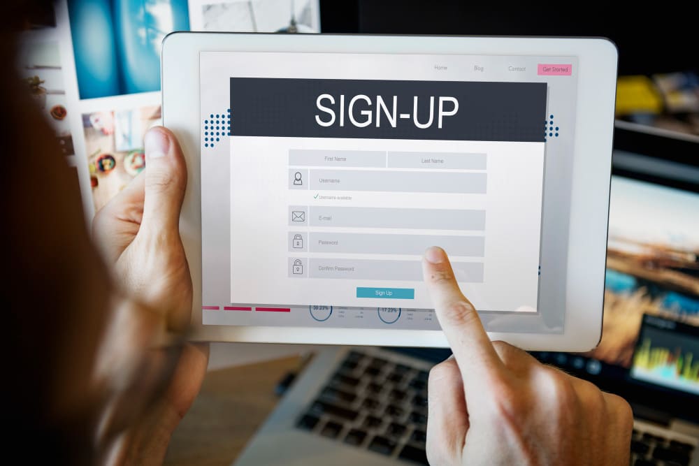 close up of someone filling out an online event registration form on a tablet.