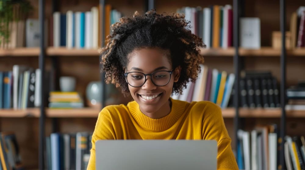 young female doing research on her laptop about the use of AI in higher education.