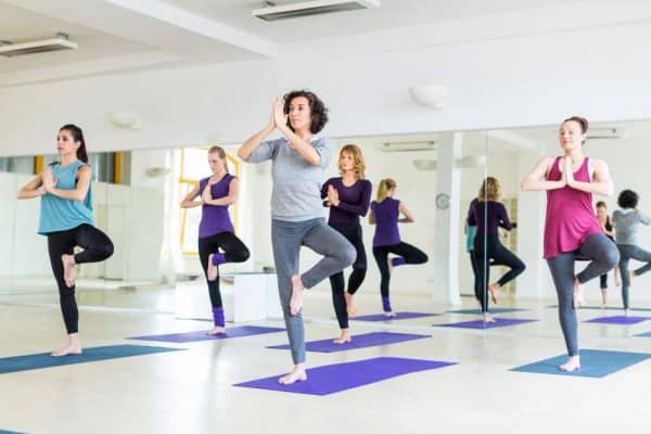 gruppo di donne che frequentano un corso di yoga programmato utilizzando Timely software per parchi e attività ricreative