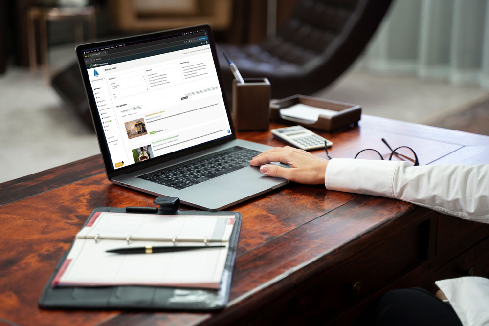 A corporate event planner desk with a Timely event calendar opened o their laptop.