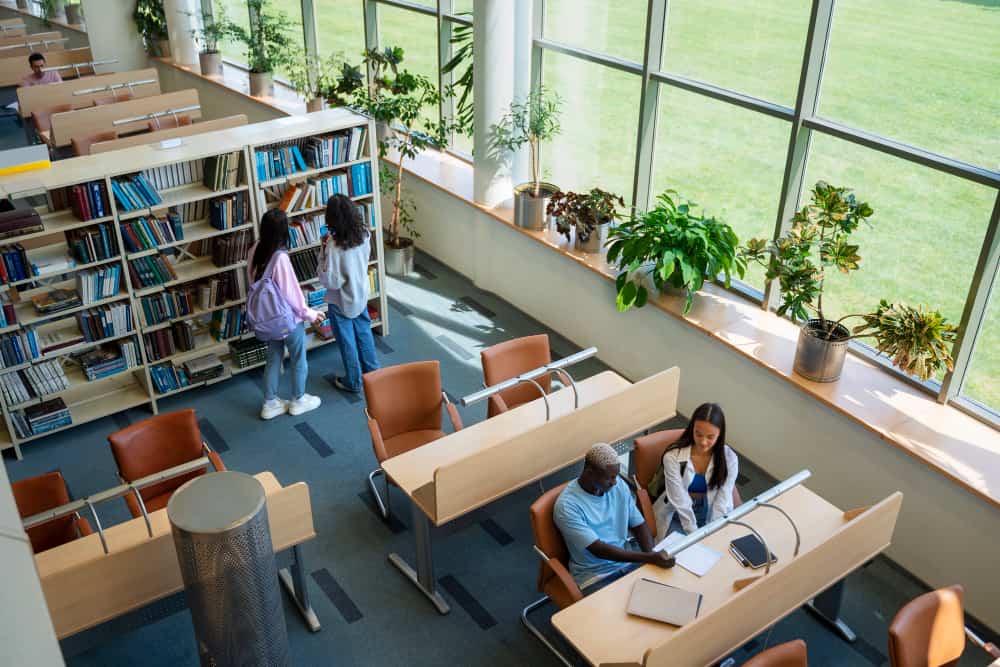 A library with wide windows and students working on a venue description example.