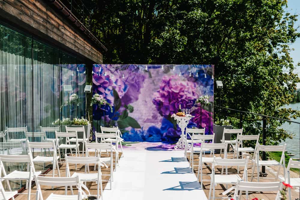 Outdoor wedding venue with a purple flower backdrop imagery to go with the venue description example.