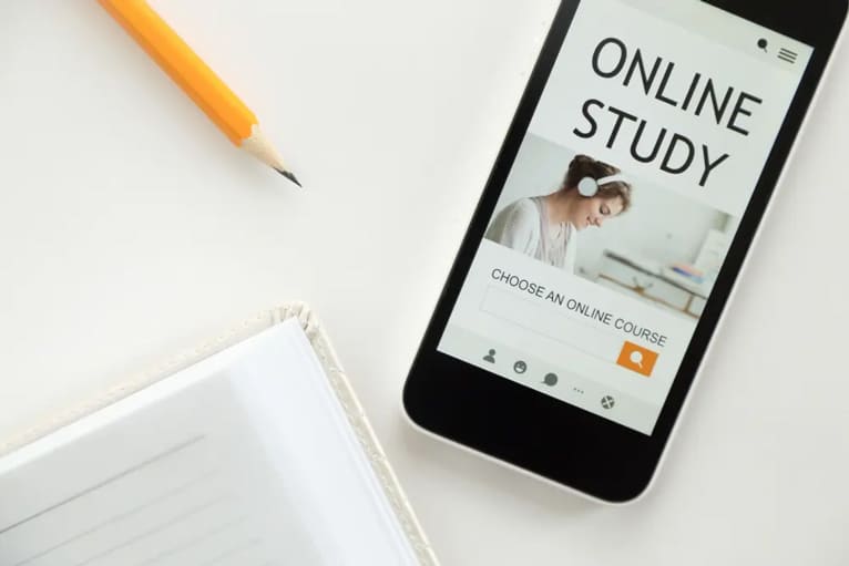 un'inquadratura ravvicinata di uno smartphone su un tavolo accanto a un taccuino e una matita gialla.