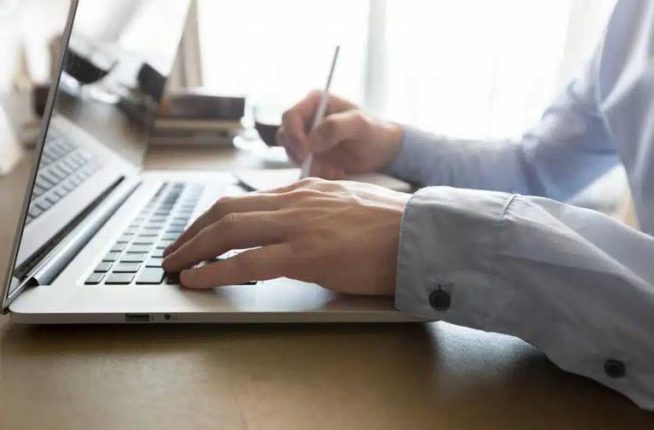liikemies käyttää ilmaista online-kalenteria kannettavalla tietokoneella