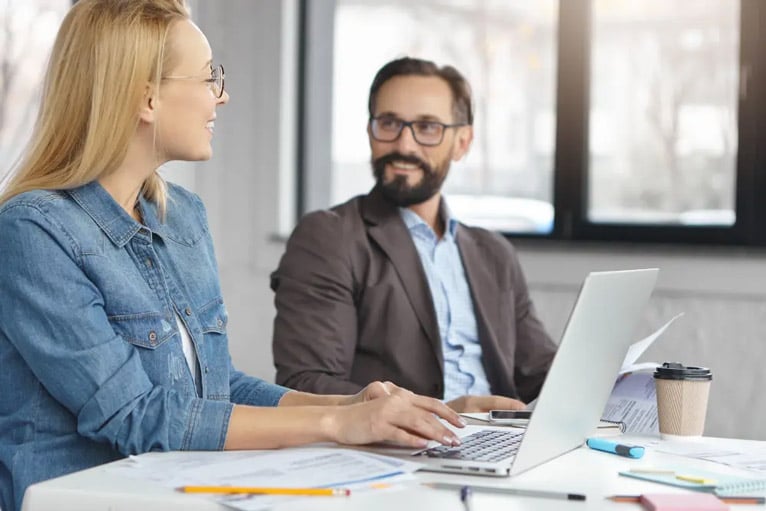 due giovani professionisti conversano animatamente sui corsi di formazione.