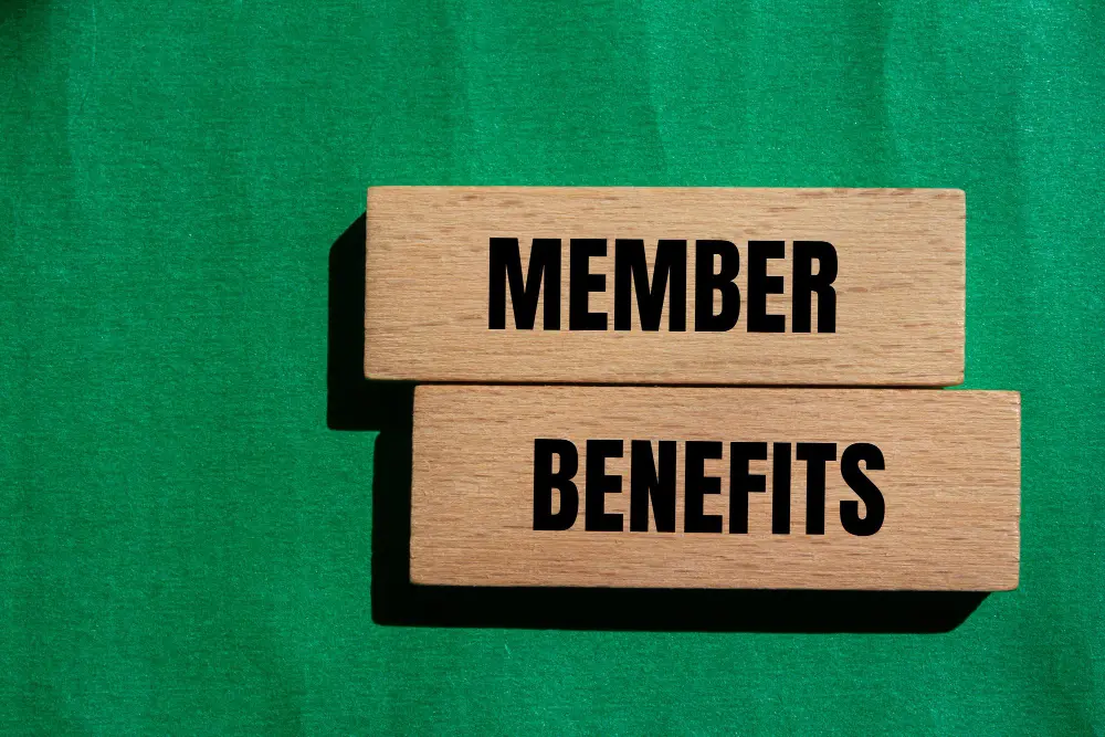 Image displaying to wooden blocks with the words member benefits written on them over a green backdrop.